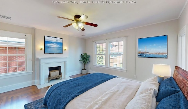 bedroom with wood-type flooring, ceiling fan, and crown molding