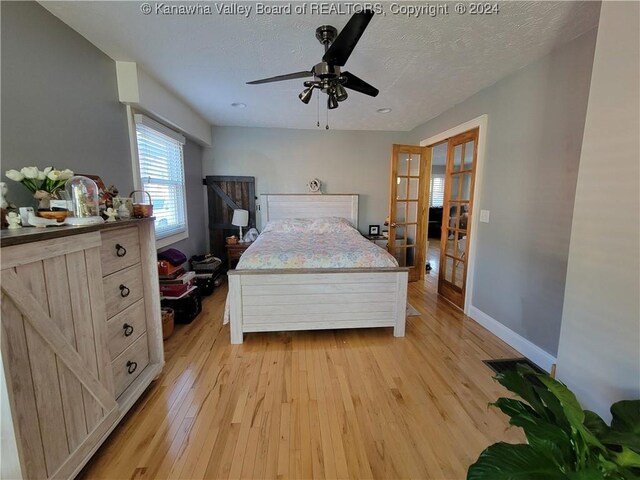 bedroom with french doors, a textured ceiling, ceiling fan, and light hardwood / wood-style floors