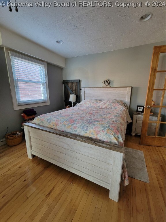 bedroom featuring a textured ceiling and light hardwood / wood-style floors