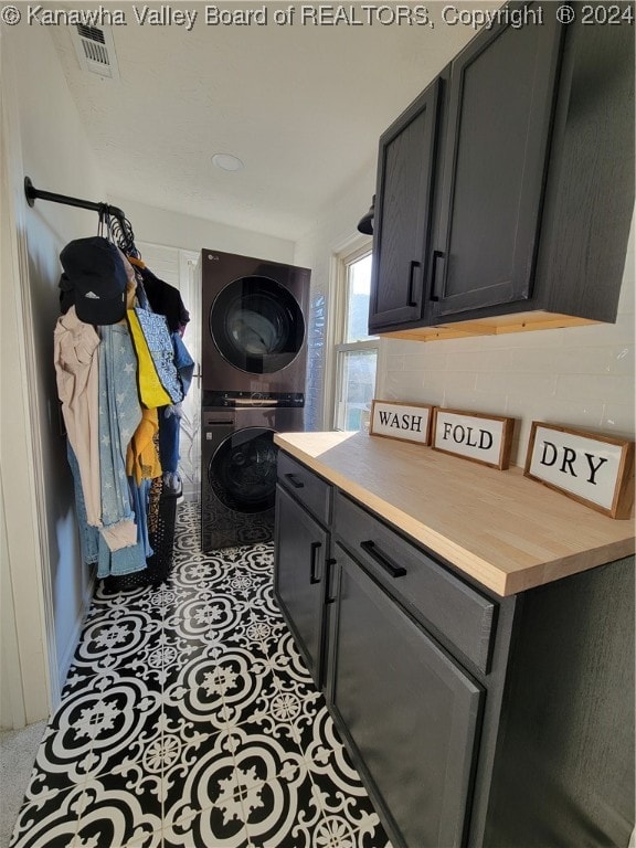 kitchen featuring stacked washing maching and dryer and decorative backsplash