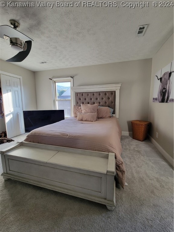 bedroom featuring a textured ceiling and carpet