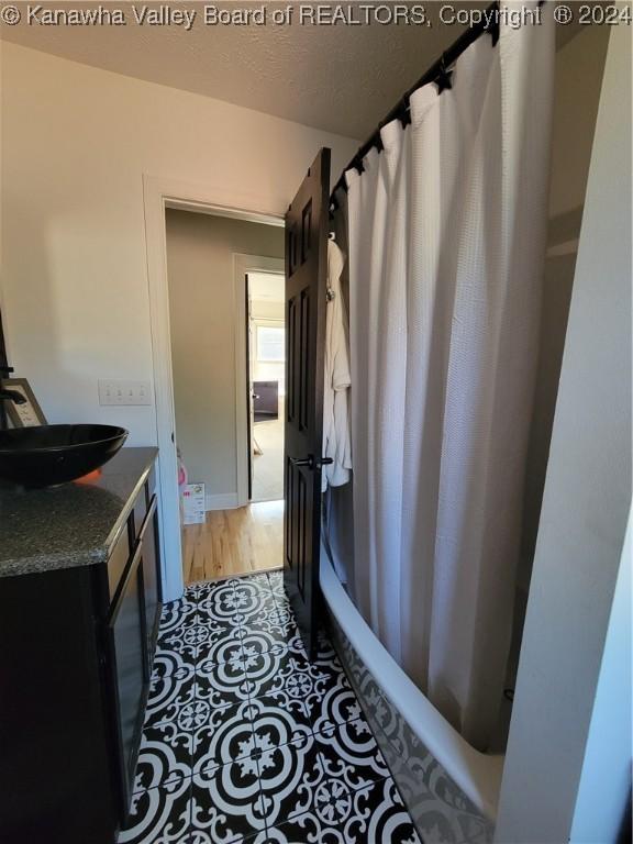 bathroom featuring vanity, wood-type flooring, and shower / bath combo