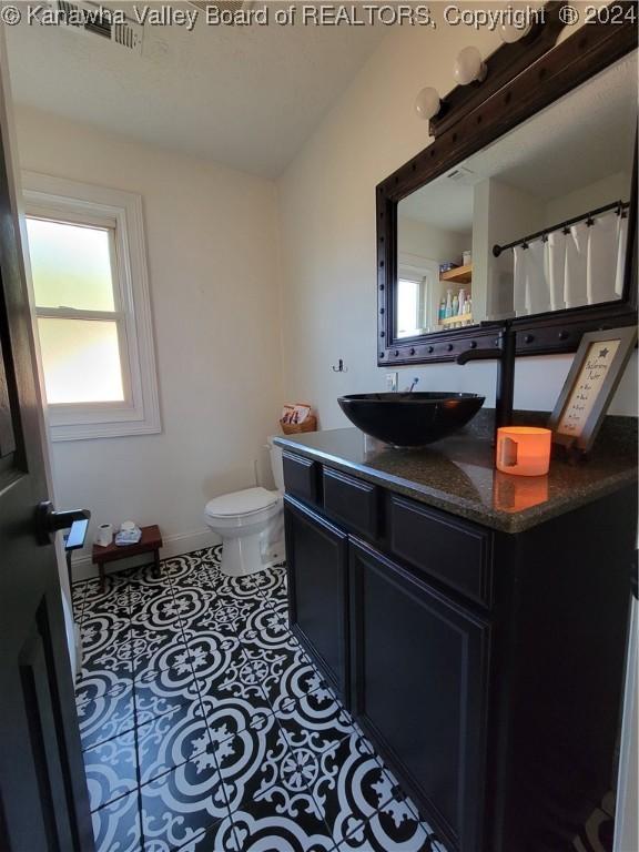 bathroom with vanity, toilet, and tile patterned floors