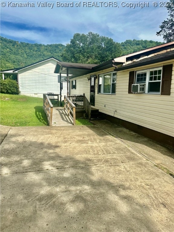 exterior space featuring cooling unit and a lawn