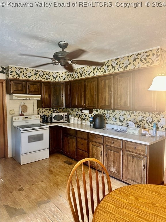 kitchen with light wood-type flooring, white appliances, tasteful backsplash, and ceiling fan