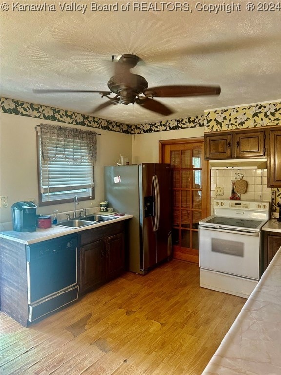 kitchen with light wood-type flooring, stainless steel fridge, white range with electric cooktop, sink, and ceiling fan