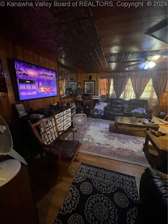 living room featuring wood walls and ceiling fan