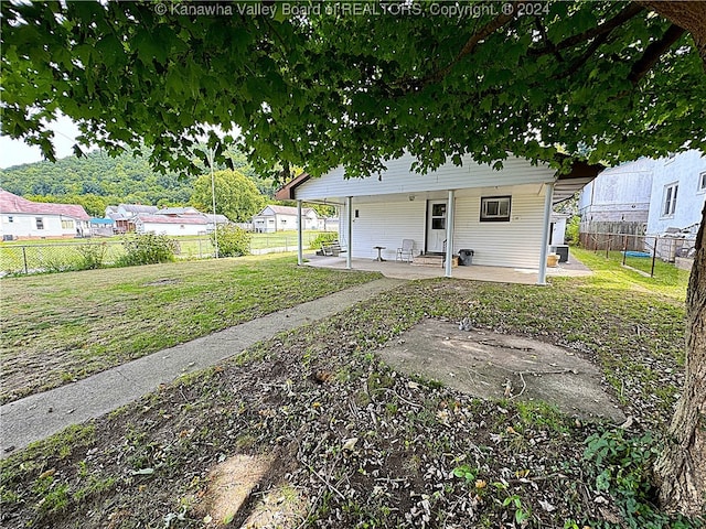 rear view of property with a yard and a patio area