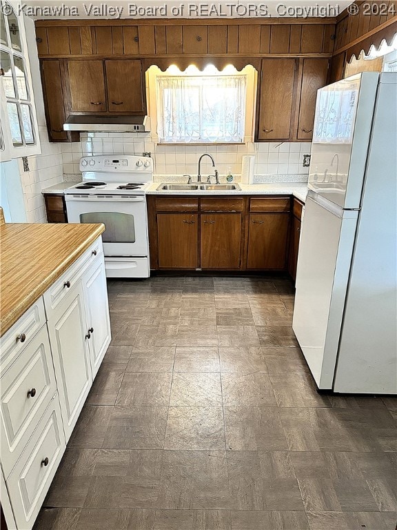 kitchen featuring sink, white appliances, white cabinets, and tasteful backsplash