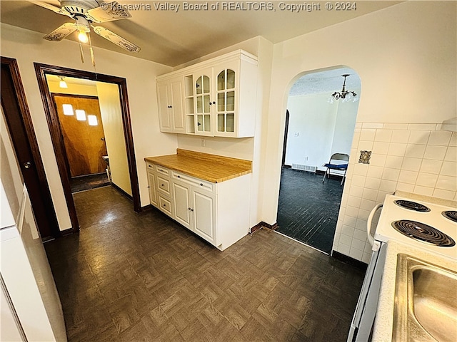 kitchen featuring tile walls, ceiling fan, electric range, white cabinetry, and wooden counters