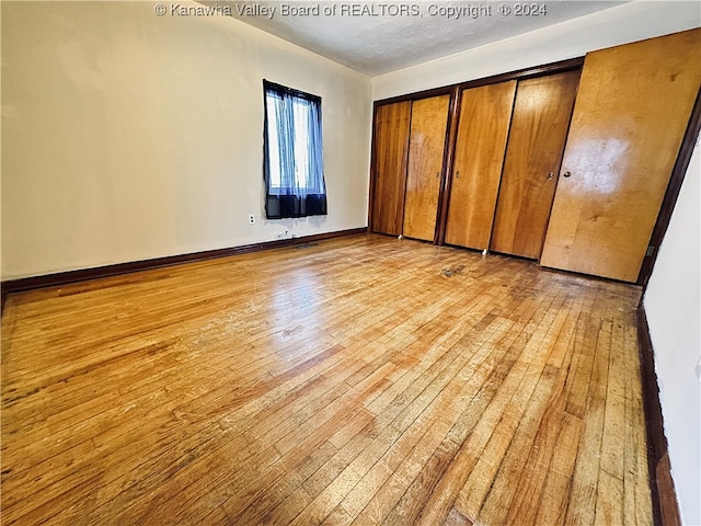 unfurnished bedroom with light hardwood / wood-style flooring and a closet