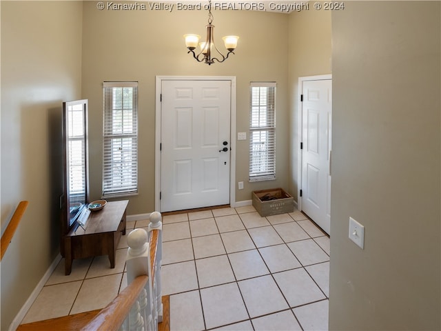 entryway featuring a notable chandelier, light tile patterned floors, and a high ceiling