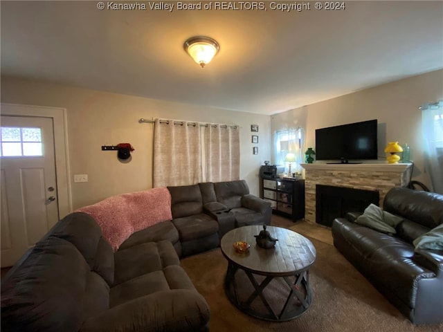 living room featuring carpet flooring and a stone fireplace