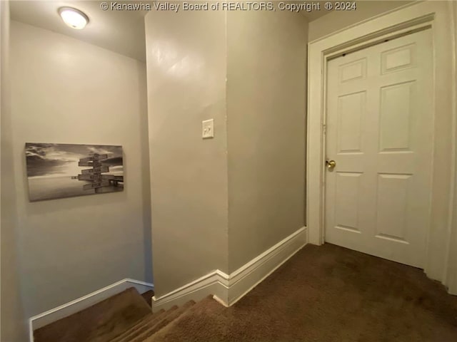 corridor featuring dark colored carpet