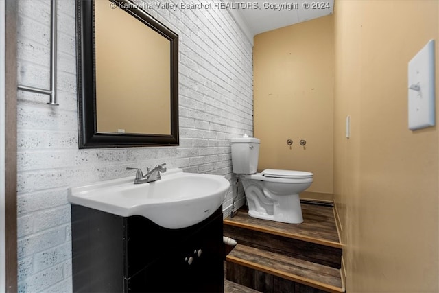 bathroom with wood-type flooring, toilet, and vanity