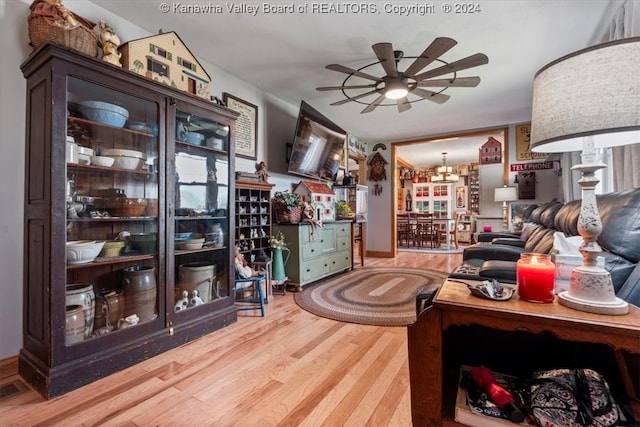 interior space featuring ceiling fan with notable chandelier and hardwood / wood-style floors