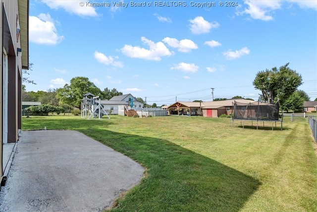 view of yard featuring a trampoline, a storage shed, and a patio area