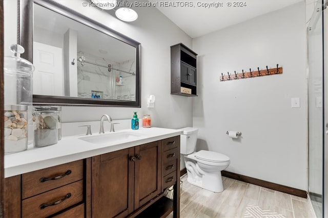 bathroom with vanity, toilet, an enclosed shower, and hardwood / wood-style flooring