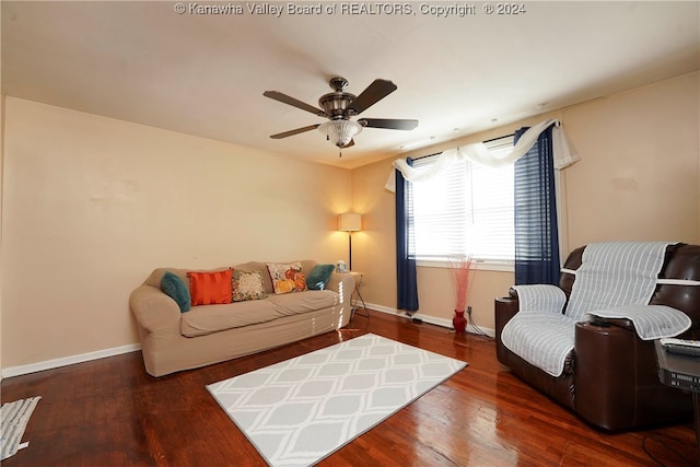 living room with dark hardwood / wood-style flooring and ceiling fan