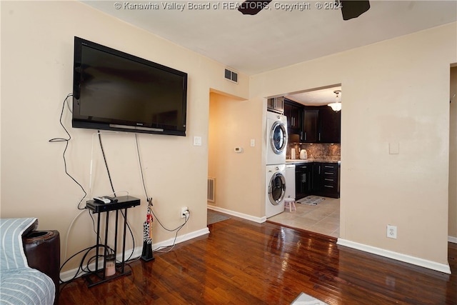 living room featuring hardwood / wood-style flooring, ceiling fan, and stacked washing maching and dryer