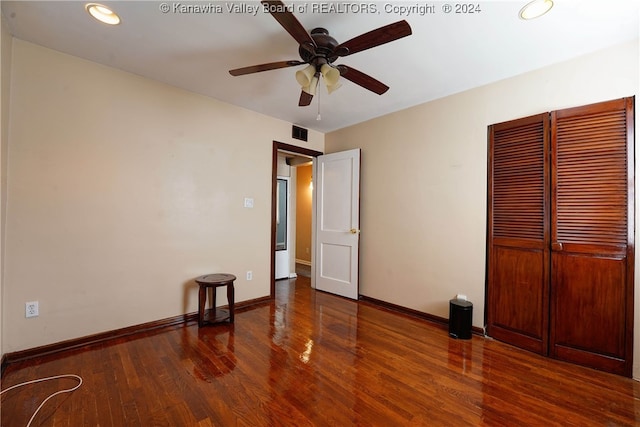 empty room featuring dark wood-type flooring and ceiling fan