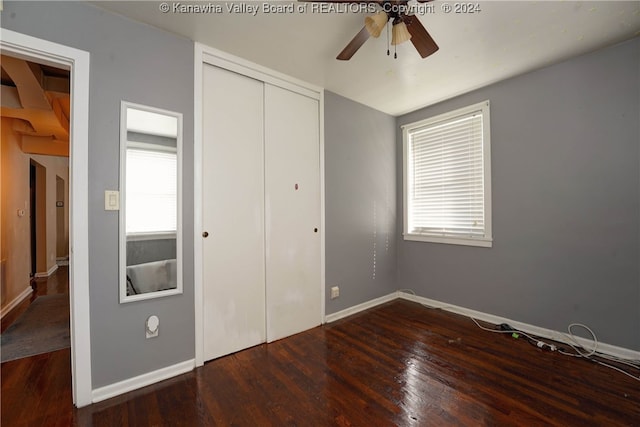 unfurnished bedroom featuring ceiling fan, dark hardwood / wood-style floors, and a closet