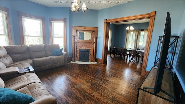 living room with dark wood-type flooring and an inviting chandelier