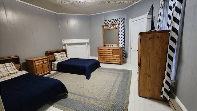 bedroom with ornamental molding and wood walls