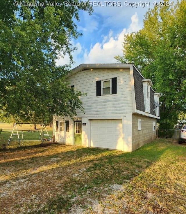 back of property featuring a yard and a garage