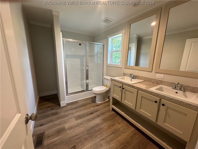 bathroom with toilet, crown molding, vanity, wood-type flooring, and a shower with shower door