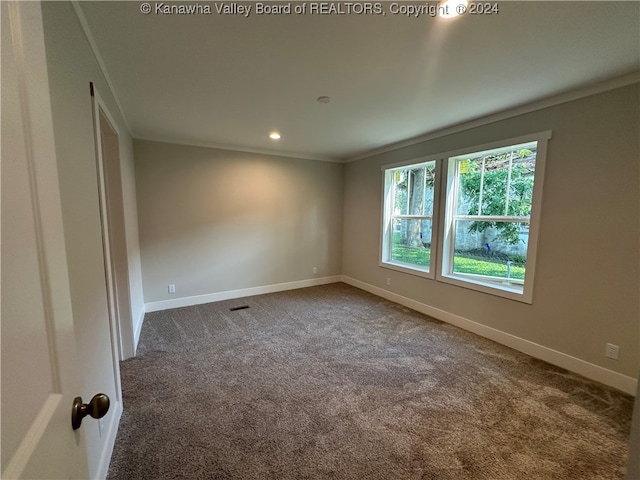 carpeted spare room featuring crown molding