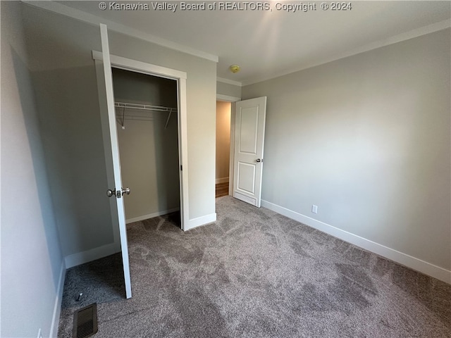 unfurnished bedroom featuring ornamental molding, a closet, and carpet