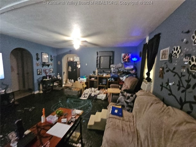 living room featuring ceiling fan and a textured ceiling