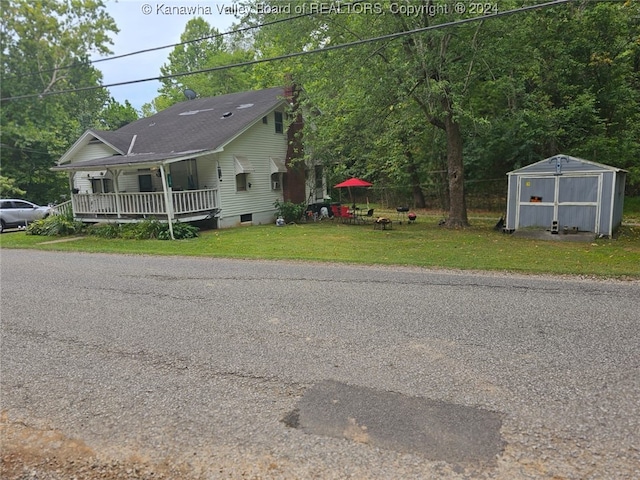 view of front facade with a storage unit, covered porch, and a front yard