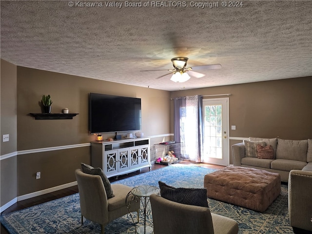 living room with a textured ceiling, wood-type flooring, and ceiling fan