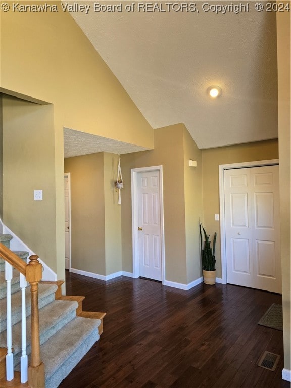 entrance foyer with vaulted ceiling and hardwood / wood-style flooring