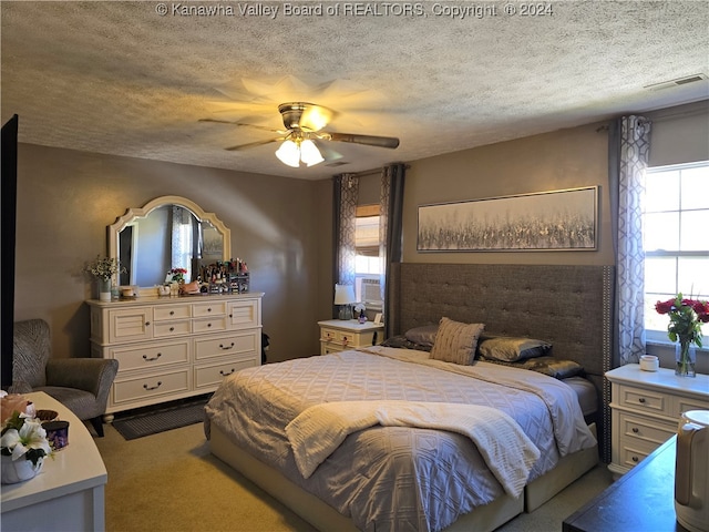 carpeted bedroom featuring a textured ceiling and ceiling fan