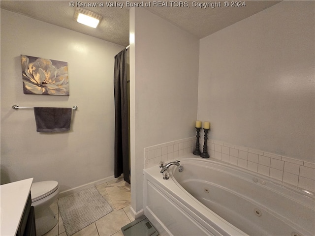 bathroom with toilet, tile patterned floors, vanity, a textured ceiling, and a bath