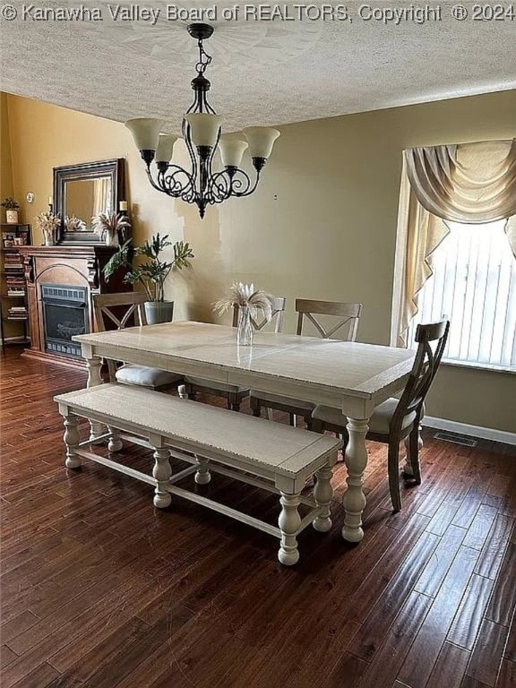 dining room featuring dark hardwood / wood-style flooring, a chandelier, and a textured ceiling