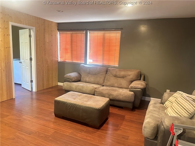 living room featuring wood-type flooring and wooden walls