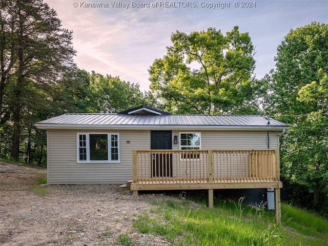 back house at dusk featuring a deck