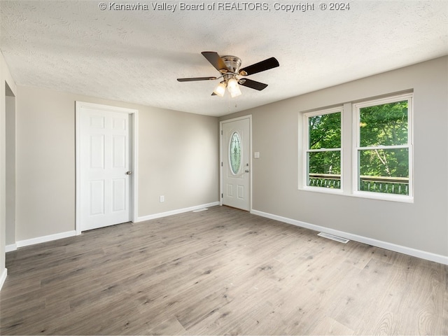 interior space with a textured ceiling, hardwood / wood-style flooring, and ceiling fan