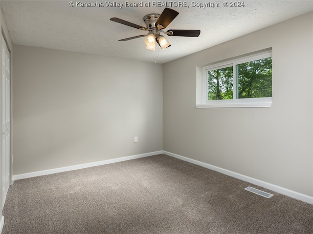 empty room with a textured ceiling, ceiling fan, and carpet flooring