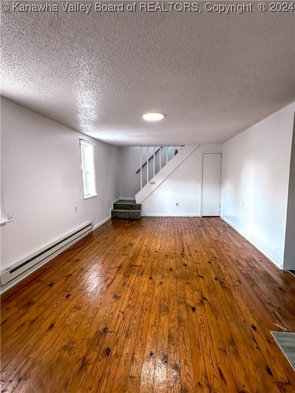 interior space featuring a baseboard radiator, hardwood / wood-style flooring, and a textured ceiling