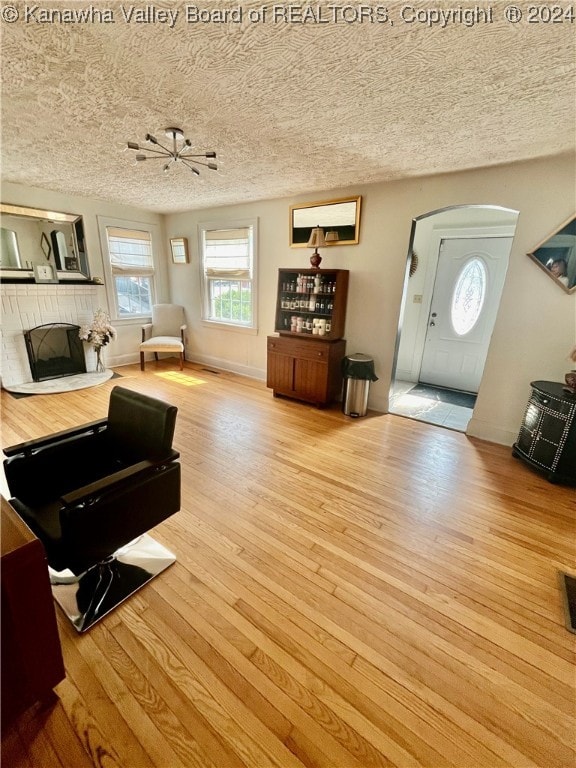 living room with a textured ceiling and light hardwood / wood-style flooring