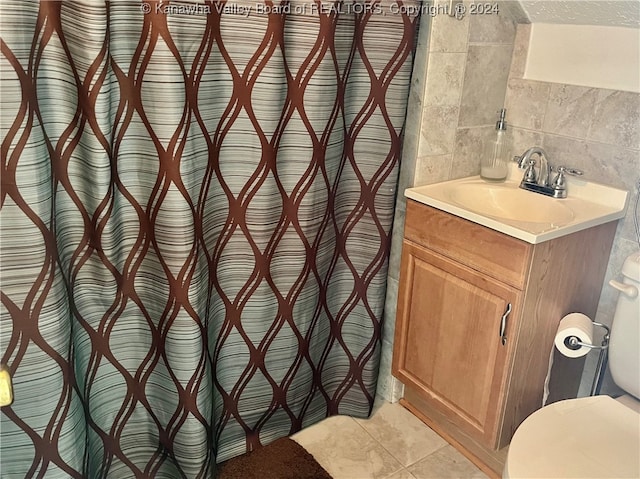 bathroom with vanity, tile walls, toilet, tile patterned floors, and decorative backsplash