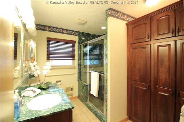 bathroom with tile patterned floors, walk in shower, a textured ceiling, and vanity