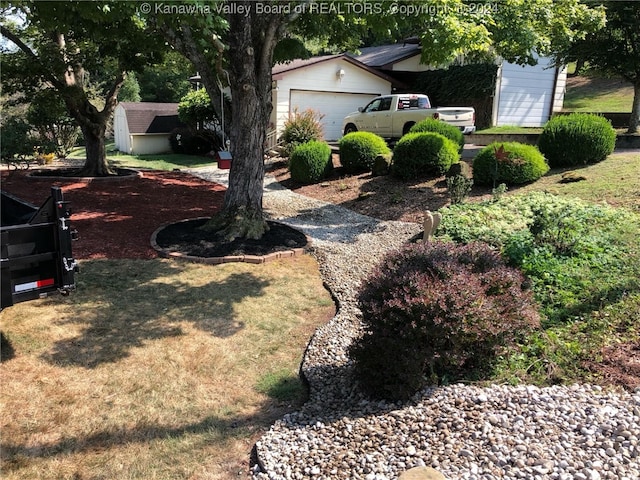 view of yard featuring a garage and an outdoor structure