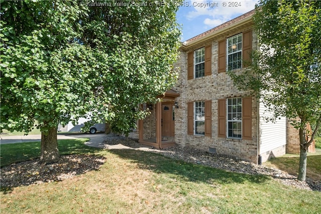 colonial-style house featuring a front yard