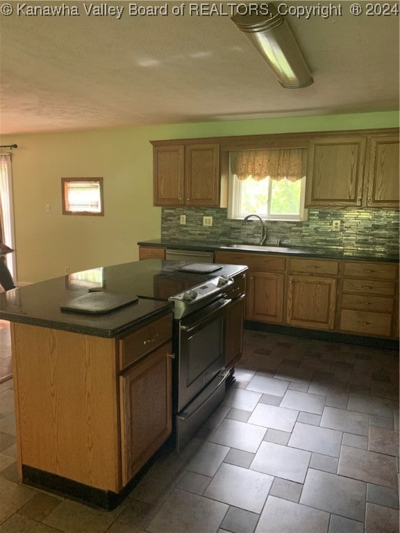 kitchen with black electric range, sink, decorative backsplash, and a center island